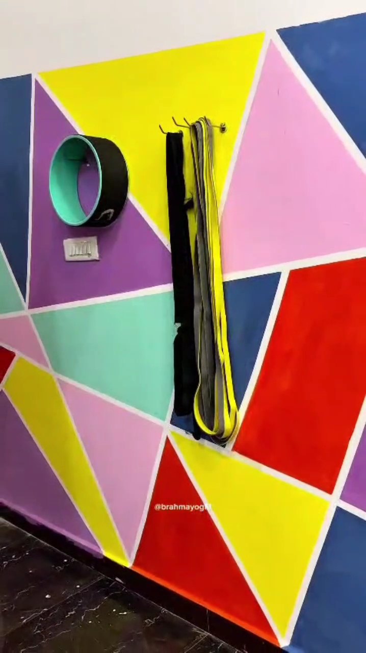 Studio ki geometric wall par wheel aur straps